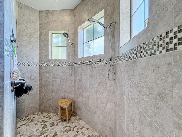 bathroom with a tile shower and plenty of natural light