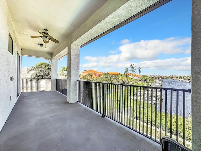 balcony featuring a water view and ceiling fan