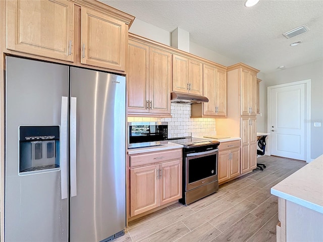 kitchen featuring light hardwood / wood-style flooring, backsplash, light brown cabinetry, appliances with stainless steel finishes, and a textured ceiling