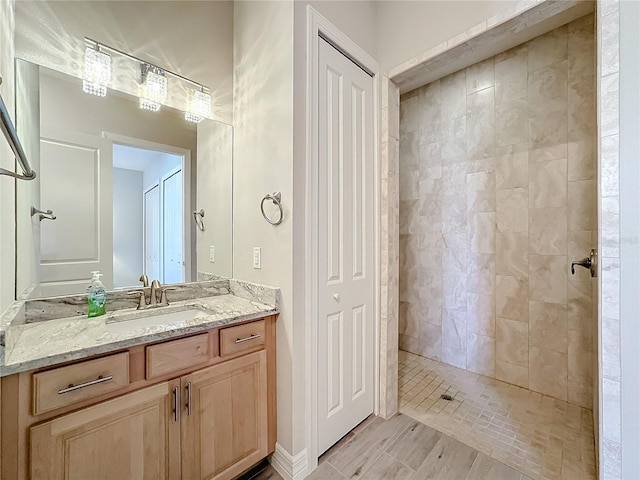 bathroom with vanity and tiled shower