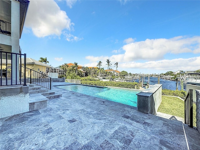 view of swimming pool with a water view and a patio area