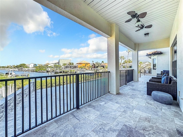 balcony with a water view and ceiling fan