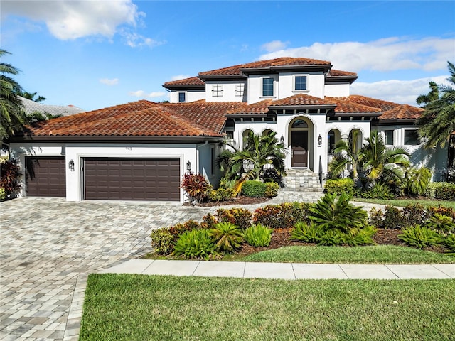 mediterranean / spanish-style home with a front yard and a garage