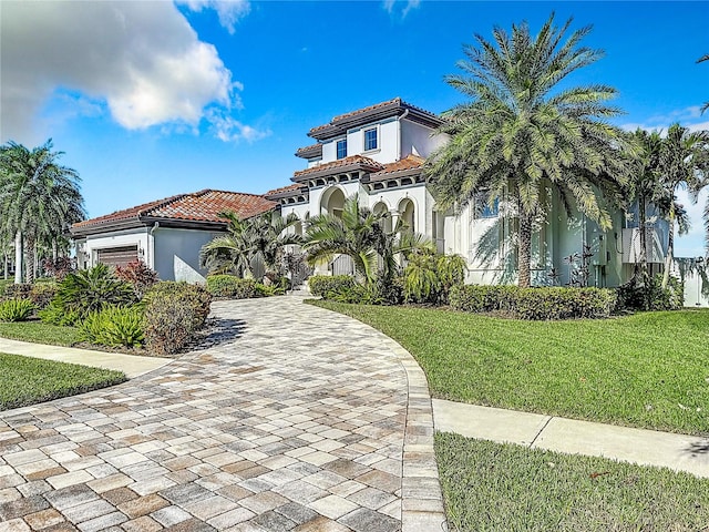 mediterranean / spanish-style house with a front lawn and a garage