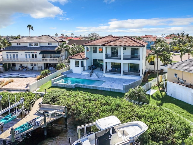 rear view of property featuring a fenced in pool and a patio area