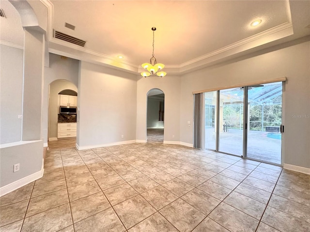 unfurnished room featuring ornamental molding, light tile patterned flooring, an inviting chandelier, and a raised ceiling