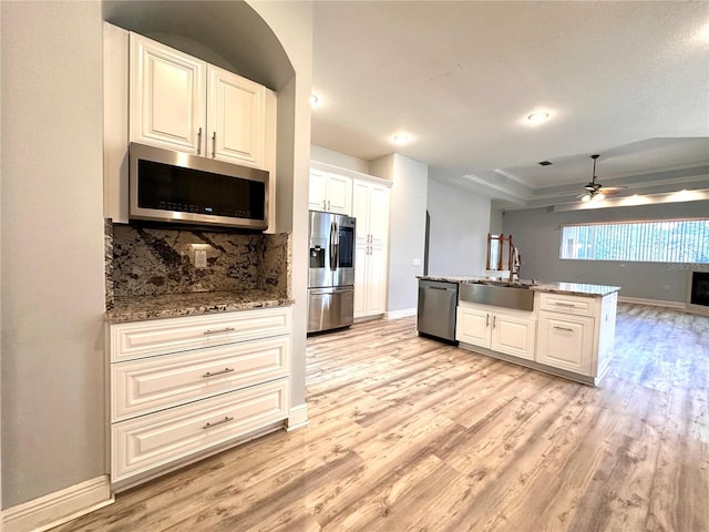 kitchen with backsplash, ceiling fan, sink, light hardwood / wood-style floors, and stainless steel appliances