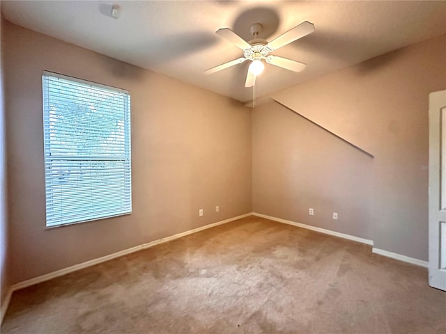 carpeted empty room featuring ceiling fan