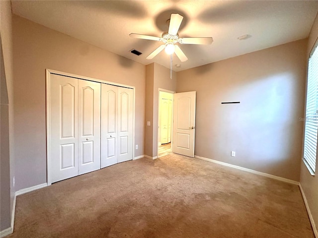 unfurnished bedroom with light carpet, a closet, and ceiling fan