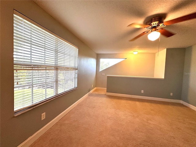 carpeted spare room featuring a textured ceiling and ceiling fan