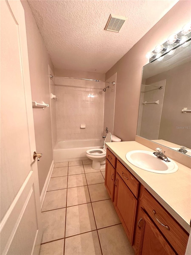 full bathroom featuring a textured ceiling, toilet, tile patterned floors, vanity, and tiled shower / bath combo