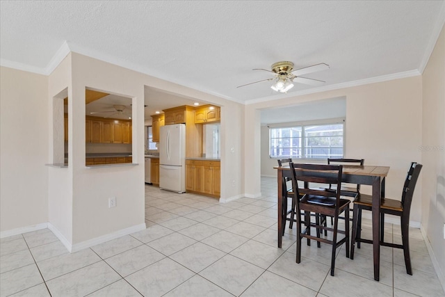 dining area with ceiling fan, crown molding, a textured ceiling, and light tile patterned floors