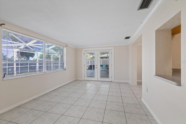 empty room with ornamental molding, french doors, and light tile patterned floors