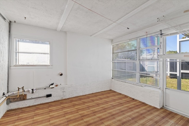 empty room with hardwood / wood-style flooring and a wealth of natural light