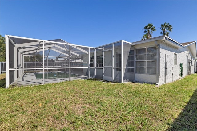 back of house featuring glass enclosure and a lawn