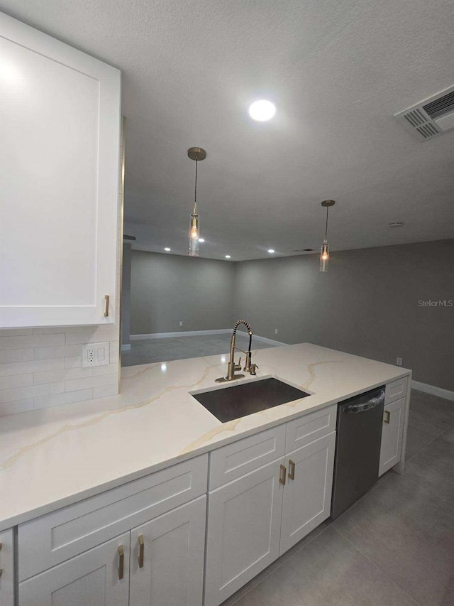 kitchen featuring dishwasher, sink, hanging light fixtures, white cabinetry, and light stone counters