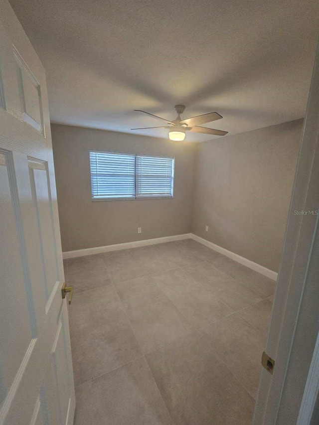 empty room with ceiling fan and a textured ceiling