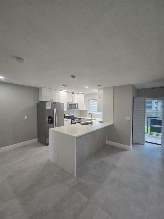 kitchen featuring white cabinetry, hanging light fixtures, stainless steel appliances, and plenty of natural light