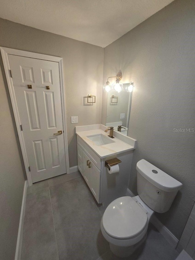 bathroom featuring vanity, toilet, and tile patterned flooring