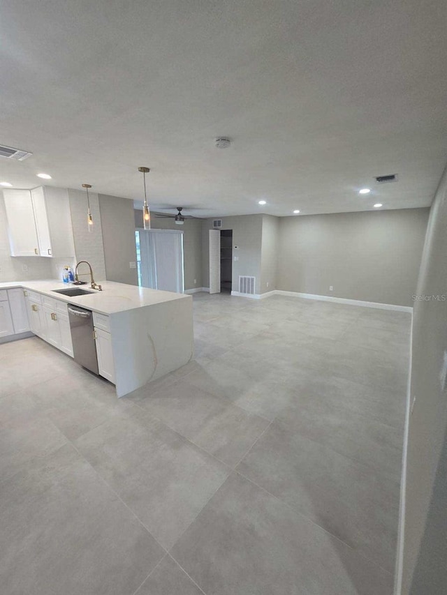 kitchen featuring white cabinets, light stone countertops, stainless steel dishwasher, sink, and decorative light fixtures