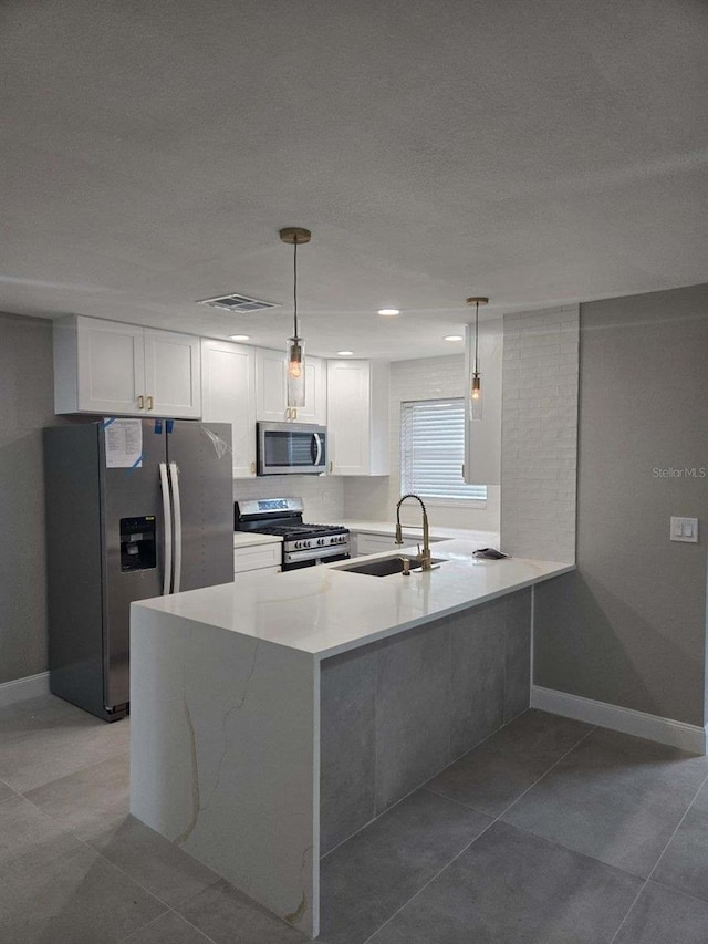 kitchen featuring white cabinets, appliances with stainless steel finishes, sink, and hanging light fixtures