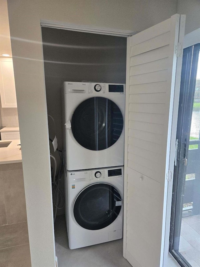 washroom featuring stacked washer and clothes dryer