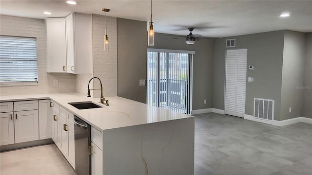 kitchen with white cabinetry, sink, light stone counters, and kitchen peninsula