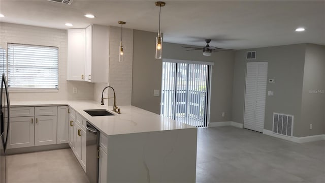 kitchen featuring light stone counters, sink, kitchen peninsula, and white cabinets