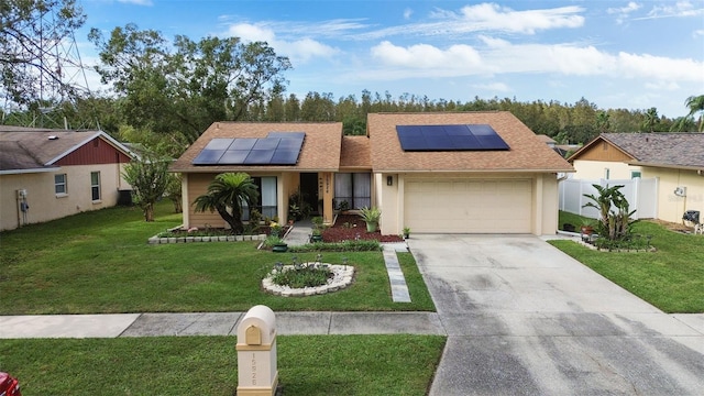 ranch-style house with a front yard, a garage, and solar panels