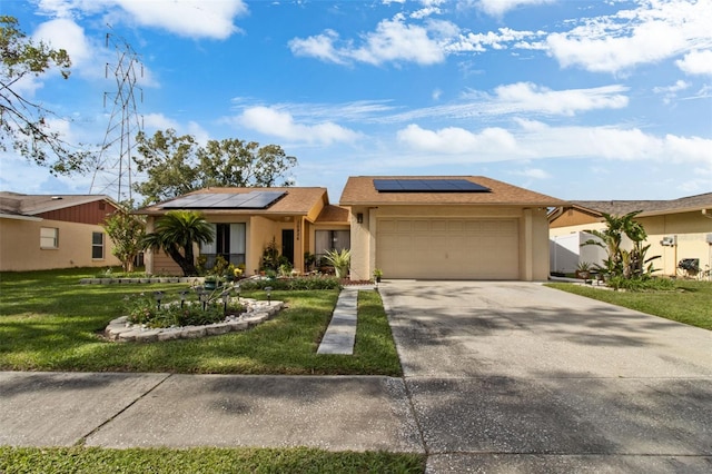 view of front of home featuring a front yard, solar panels, and a garage