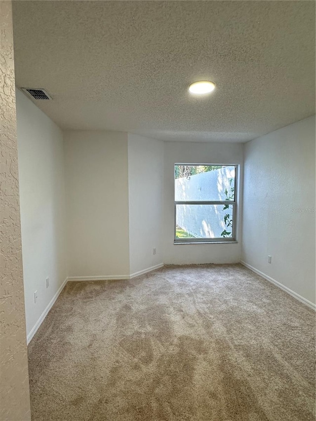 empty room featuring a textured ceiling and carpet floors