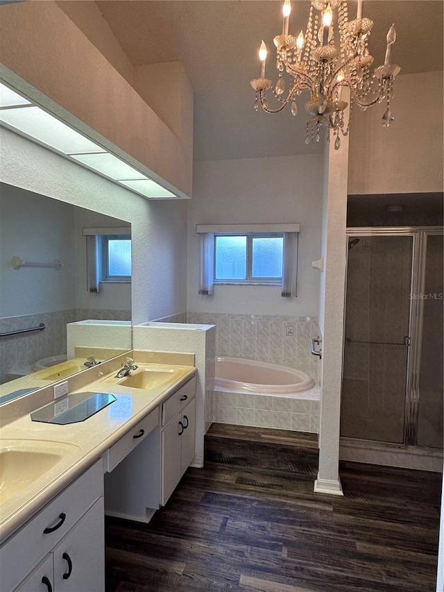 bathroom featuring vanity, independent shower and bath, hardwood / wood-style flooring, and an inviting chandelier