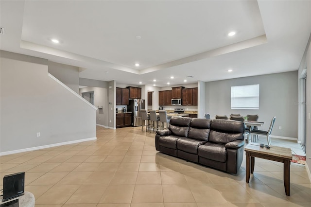 living room featuring light tile patterned floors and a raised ceiling