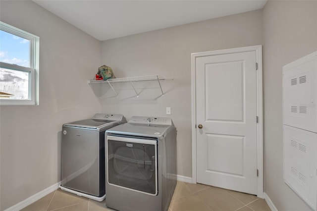 laundry room with light tile patterned floors and washing machine and clothes dryer