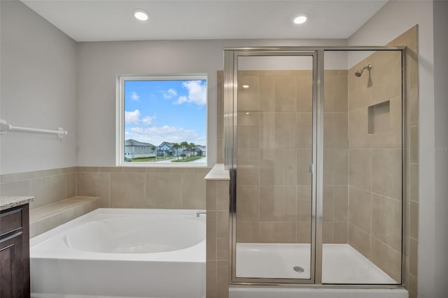 bathroom featuring vanity and independent shower and bath