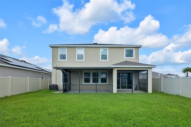 rear view of house with a sunroom, cooling unit, and a lawn