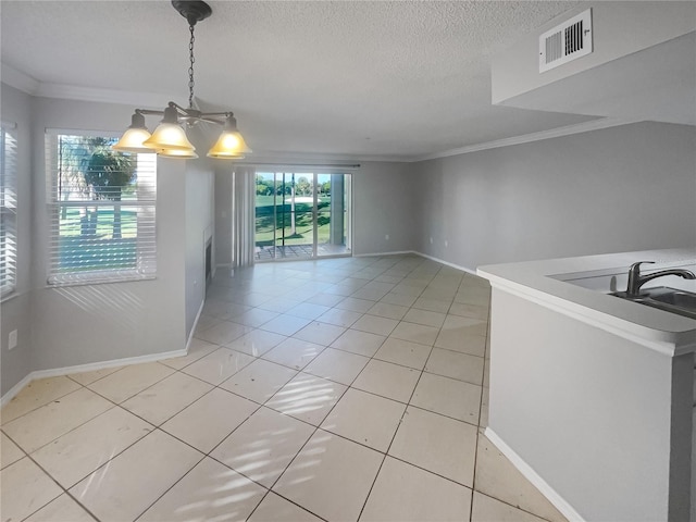 unfurnished dining area with sink, crown molding, an inviting chandelier, light tile patterned floors, and a textured ceiling