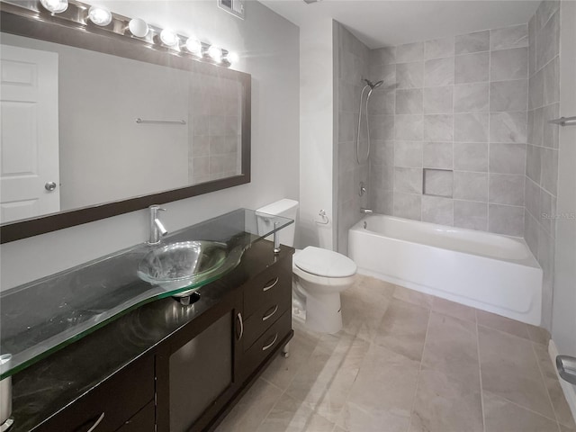 full bathroom featuring tiled shower / bath, vanity, and toilet