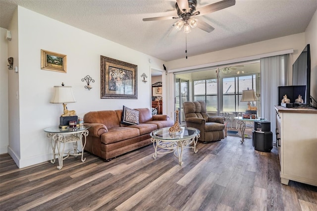 living room featuring ceiling fan, a textured ceiling, and dark hardwood / wood-style flooring