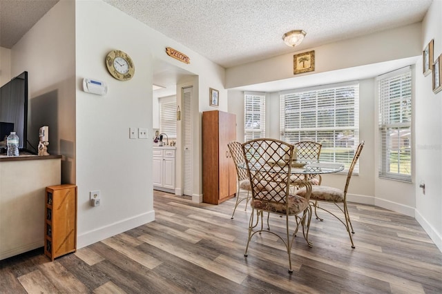 dining room featuring hardwood / wood-style floors and a textured ceiling