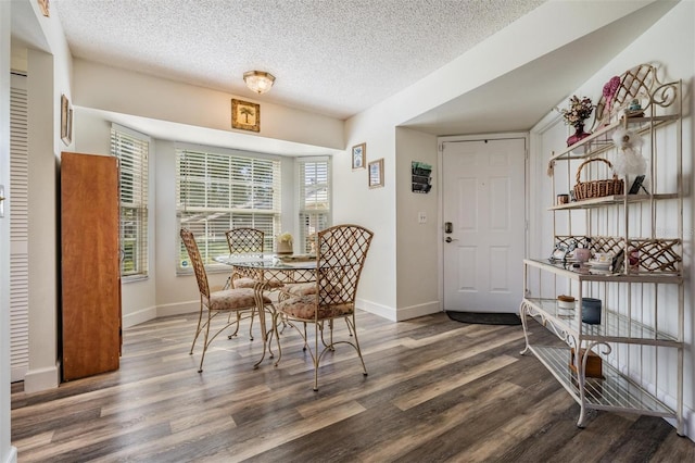 dining space featuring a textured ceiling and dark wood-type flooring