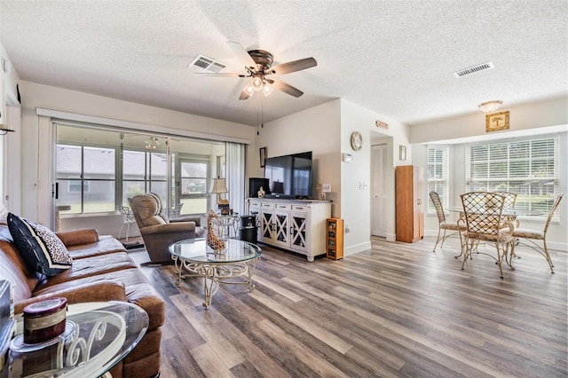 living room with hardwood / wood-style floors, a textured ceiling, and ceiling fan