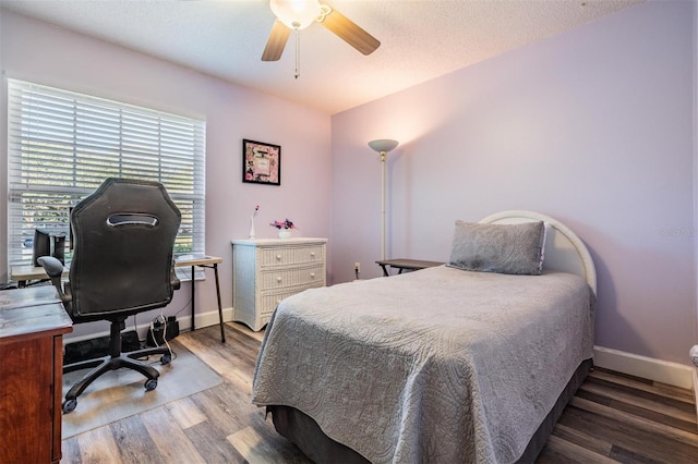 bedroom with ceiling fan, hardwood / wood-style flooring, and a textured ceiling