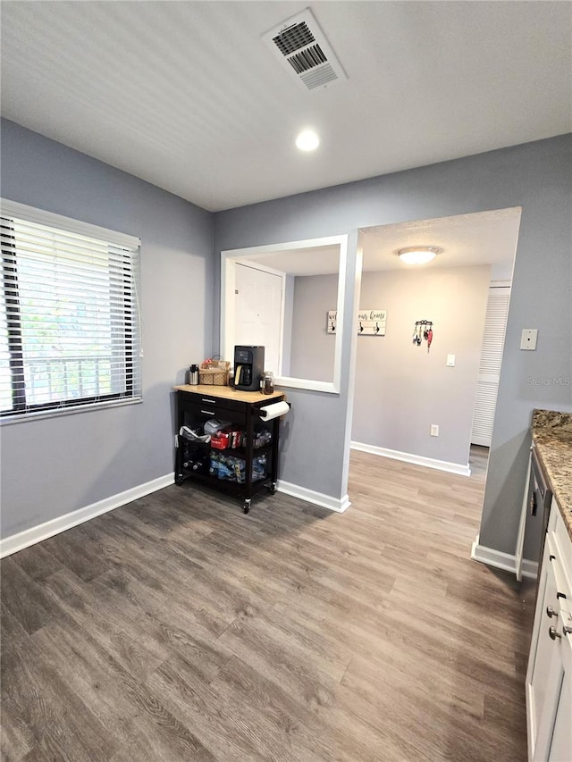 interior space featuring white cabinets, stone counters, and hardwood / wood-style floors