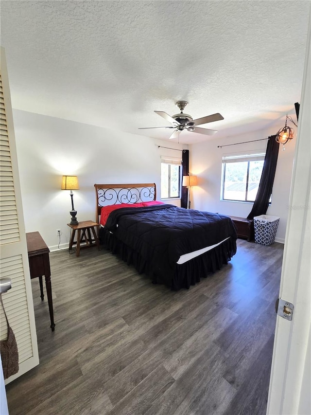 bedroom featuring ceiling fan, dark wood-type flooring, and a textured ceiling