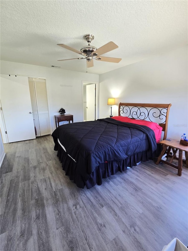 bedroom featuring a textured ceiling, ceiling fan, and hardwood / wood-style floors