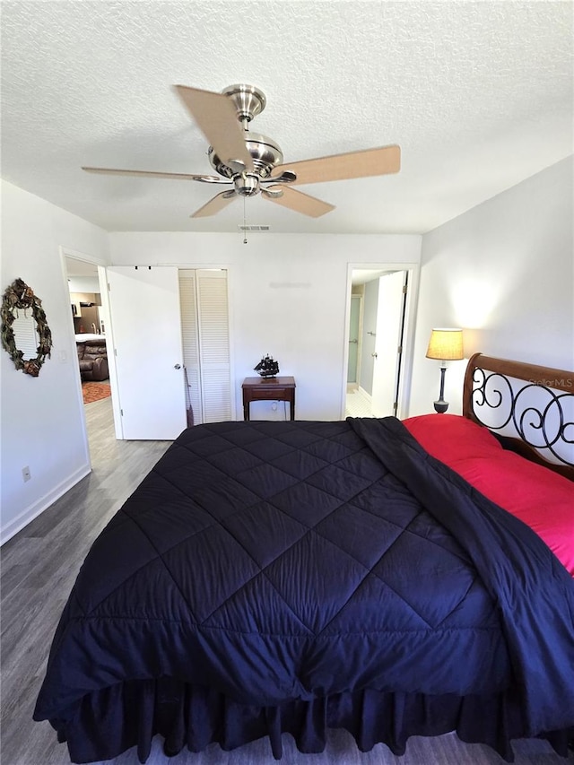 bedroom featuring ceiling fan, wood-type flooring, and a textured ceiling