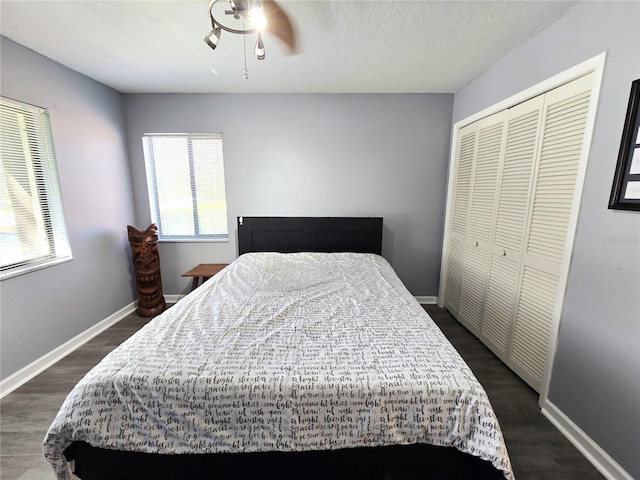 bedroom with ceiling fan, dark hardwood / wood-style flooring, and a closet