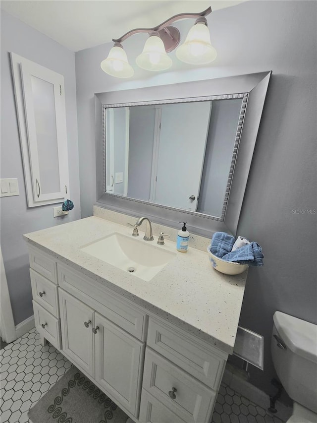 bathroom featuring toilet, tile patterned flooring, and vanity