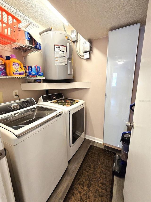 washroom with washer and clothes dryer, water heater, dark wood-type flooring, and a textured ceiling